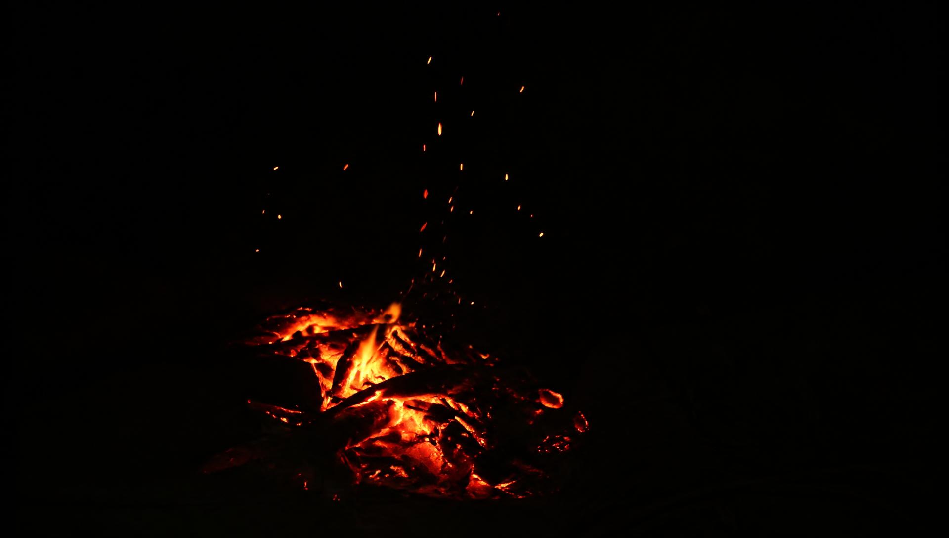 Embers rising from a fire at night